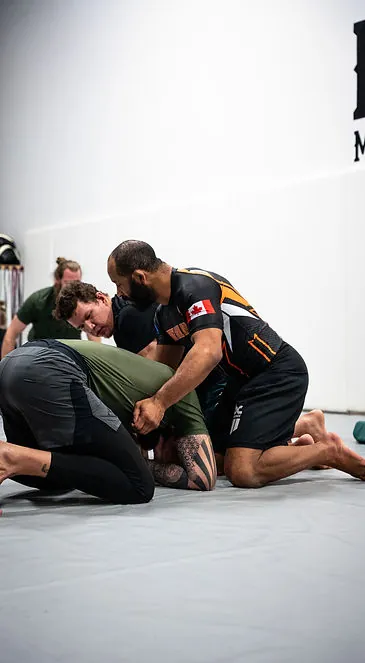 Adult grapplers drilling No Gi techniques during class at Mission BJJ